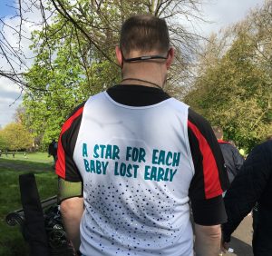 Miscarriage Association supporter wearing a running vest covered in stars in memory of babies lost early.