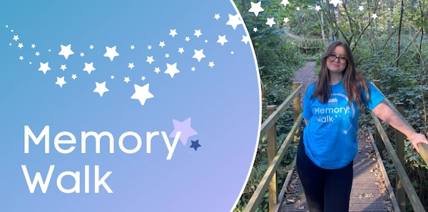 Baby Loss Awareness Week Memory Walk supporter walking outdoors in Miscarriage Association t-shirt, event banner with star design