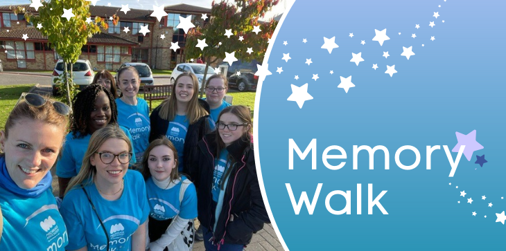 Group of Miscarriage Association fundraisers in blue Memory Walk t-shirts smiling together outdoors, with banner text 'Memory Walk' and star graphics